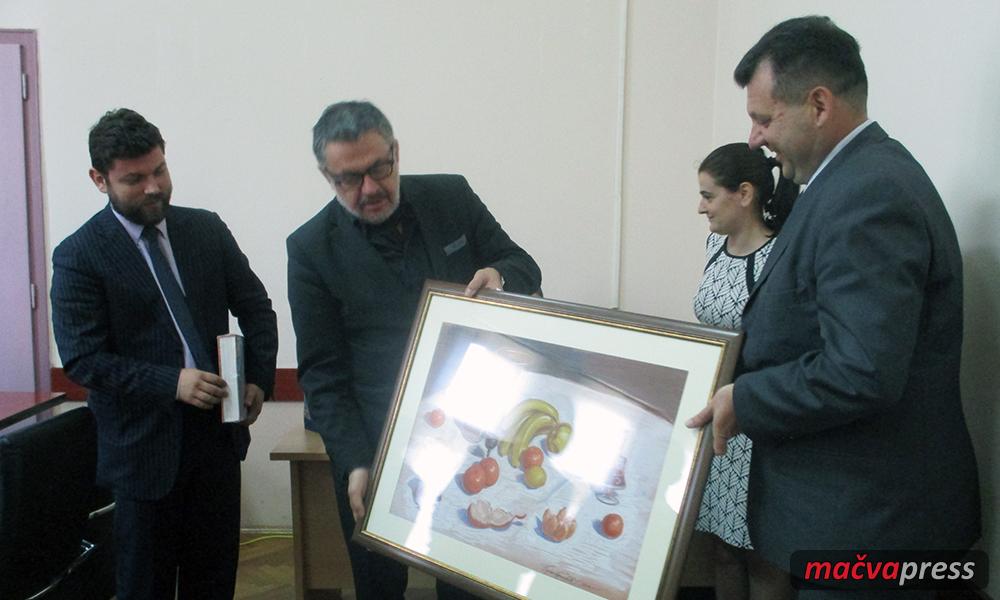 Slika naslovna Ambasador - Mimo protokola - šala i smeh:  Ambasadoru poklonili platno sa "plodovima iz Mačve"